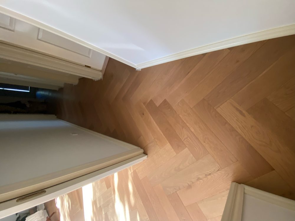 Real Ghane Flooring project: herringbone oak flooring running down a hallway